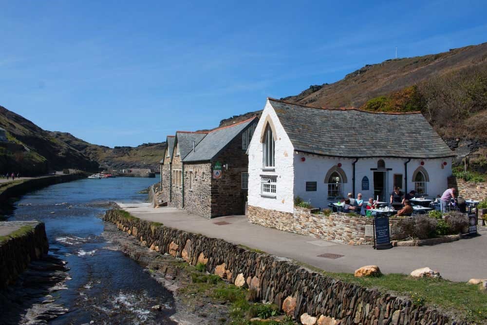 Stone and white houses overlooking an estuary.