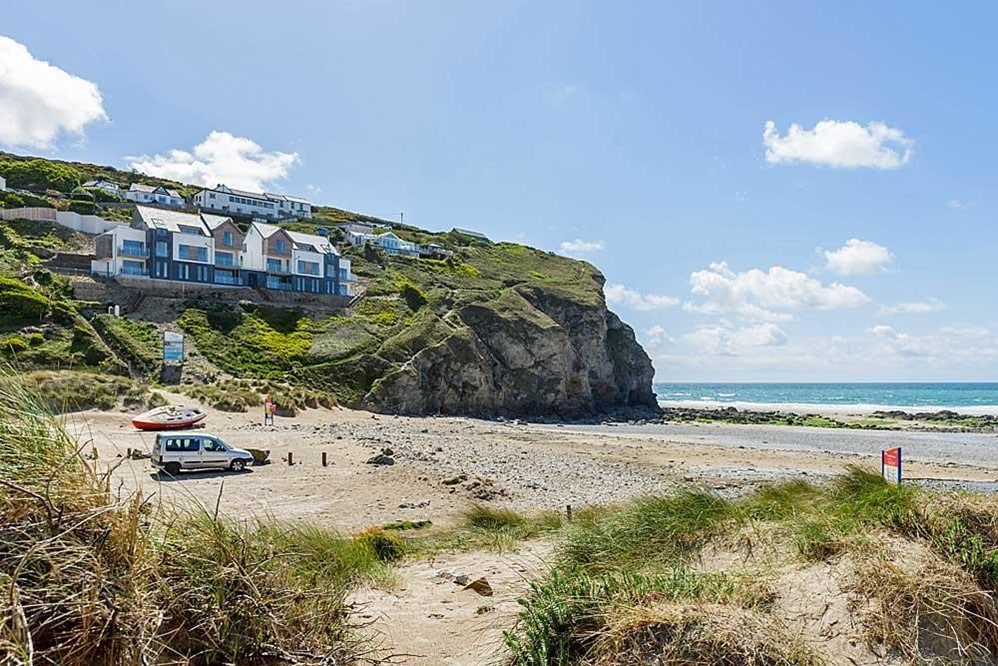 A beach with houses and a car on the side.