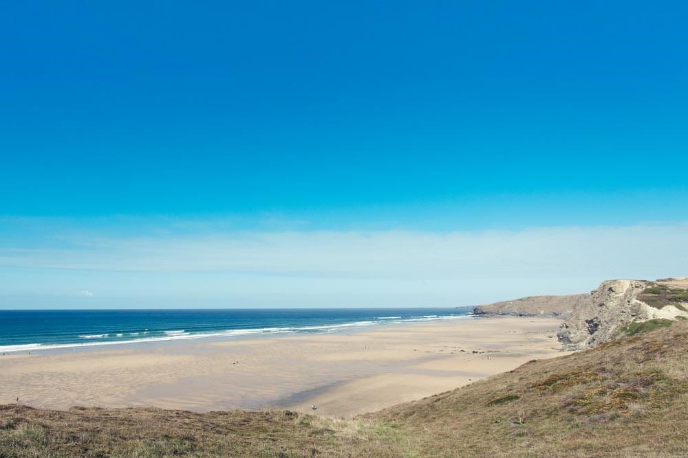 Beach with waves rolling in and a blue sky. 