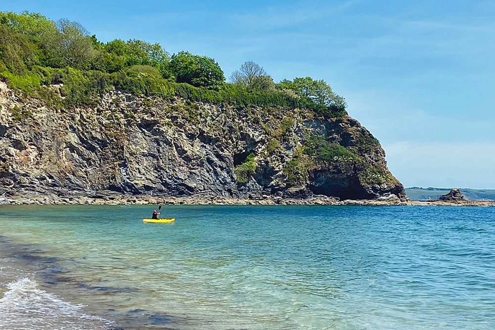 A person in a yellow kayak in the water.