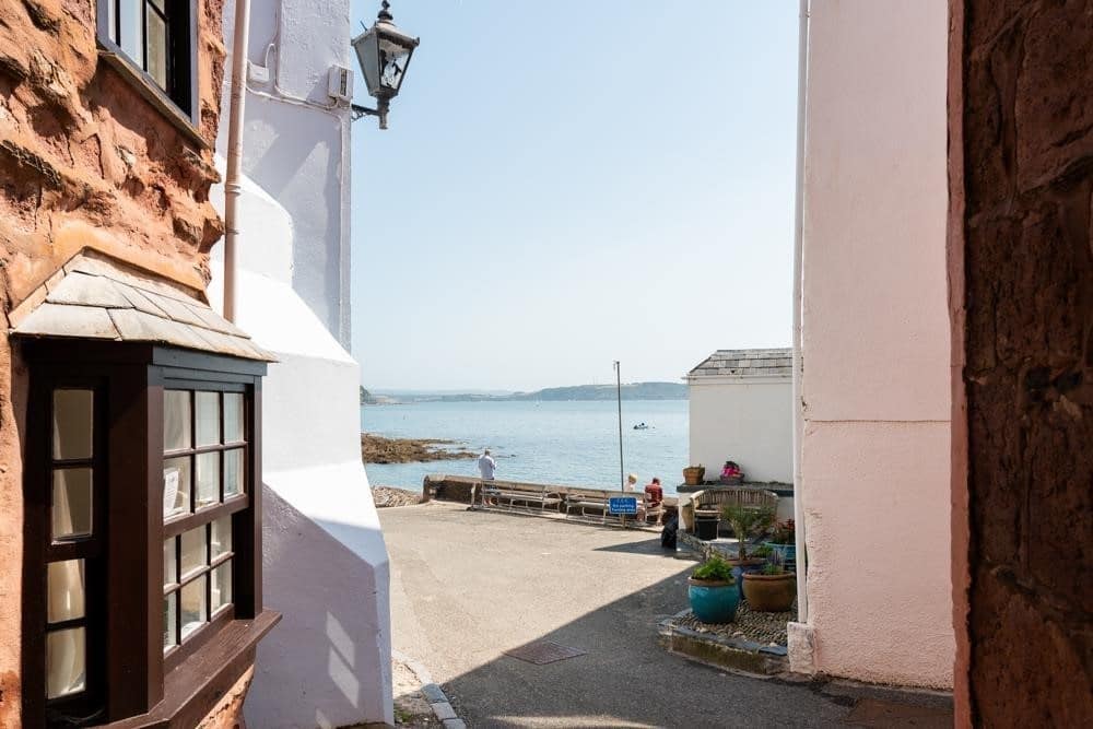 A view of a beach from a narrow street. 