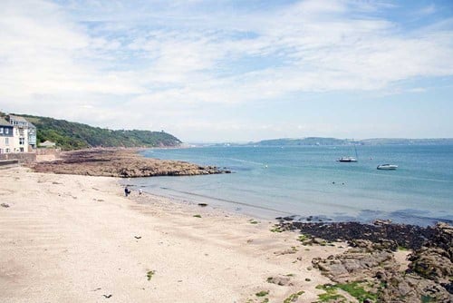 A beach with rocks and blue water.