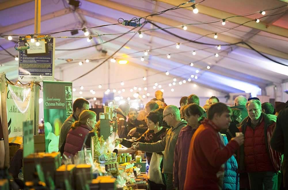 A group of people in a tented market. 