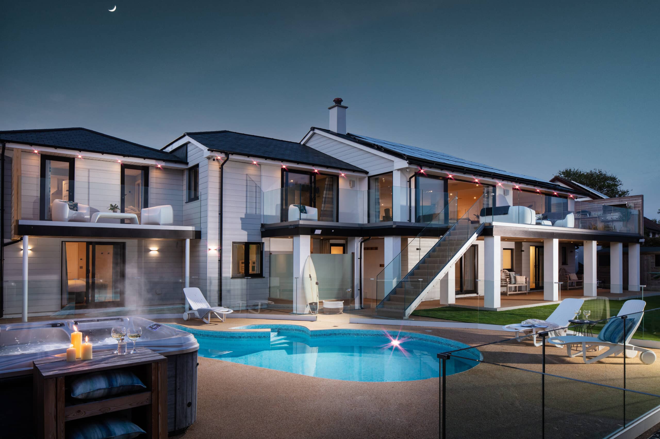 Large house with swimming pool and hot tub at night