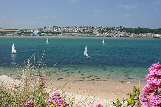 Yachts sailing across an estuary on a sunny day.