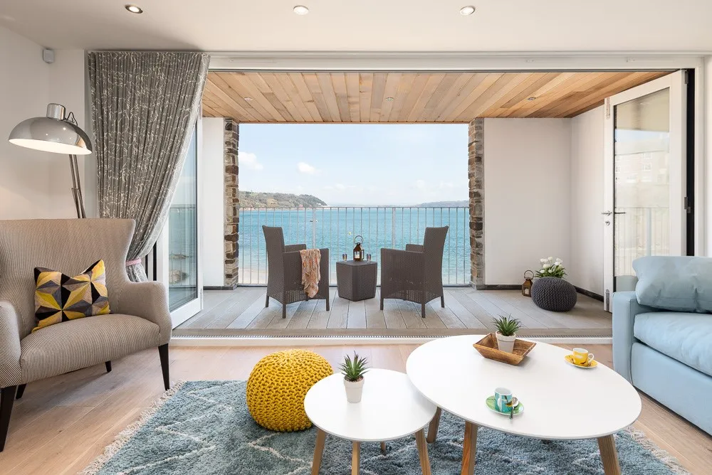 A living room with a view of the ocean from the balcony. 