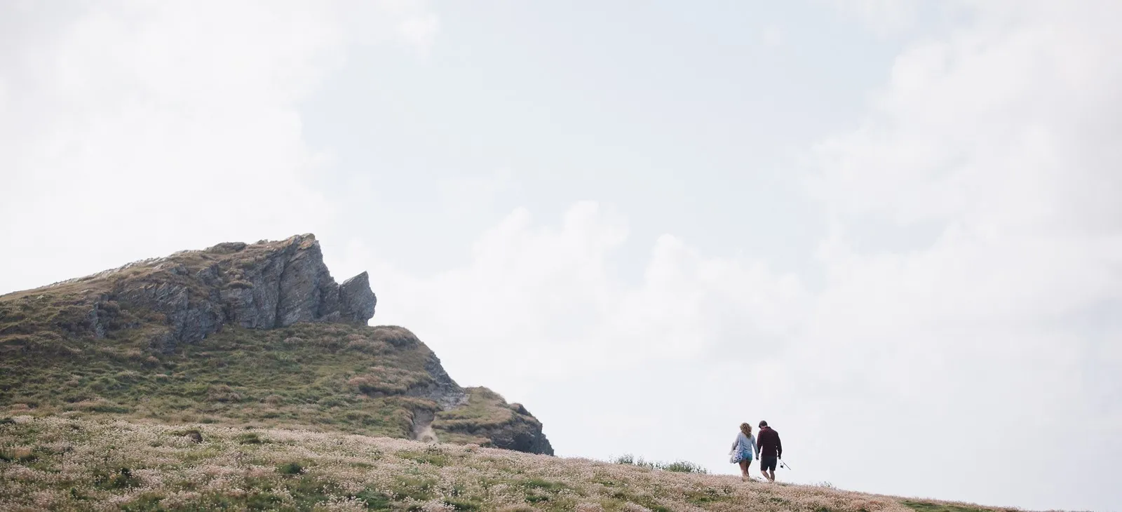 Couple walking across cliffs.
