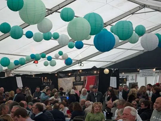 A group of people sitting in a marquee.
