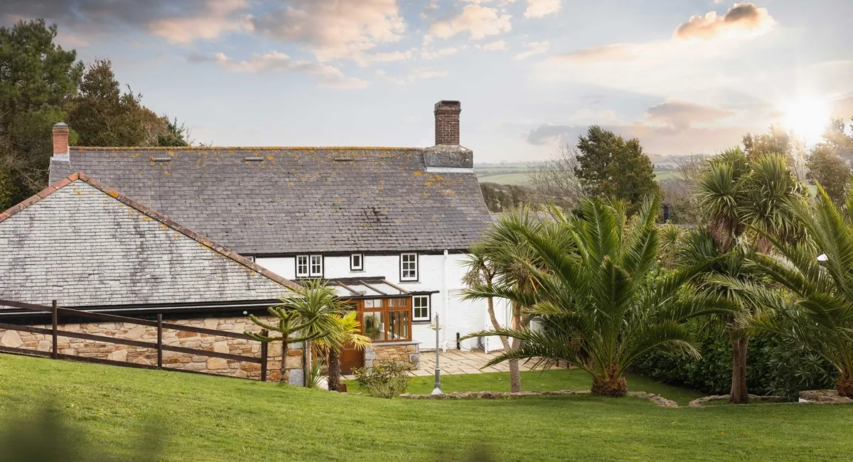 A white house with a stone wall.