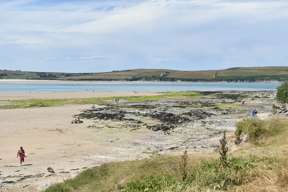 People walking across the beach at low tide.