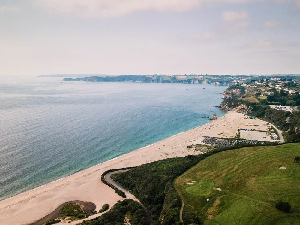 A white sand beach overlooked by a golf course.