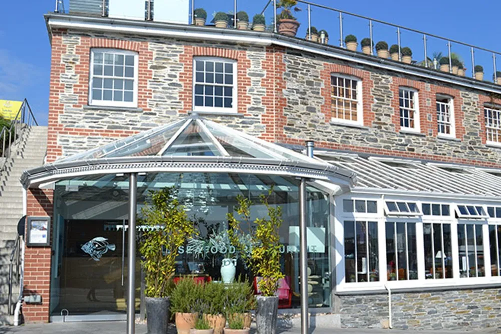 A glass building with a rooftop balcony. 