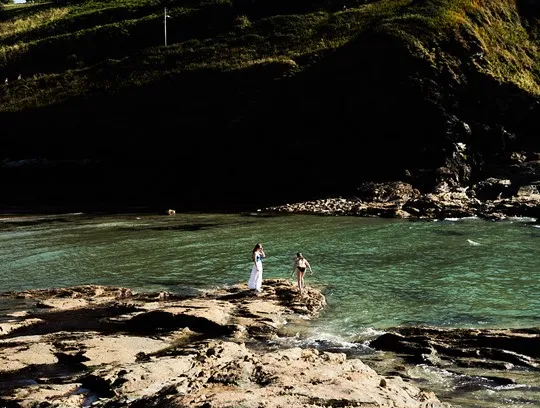 A group of people standing on rocks in water.