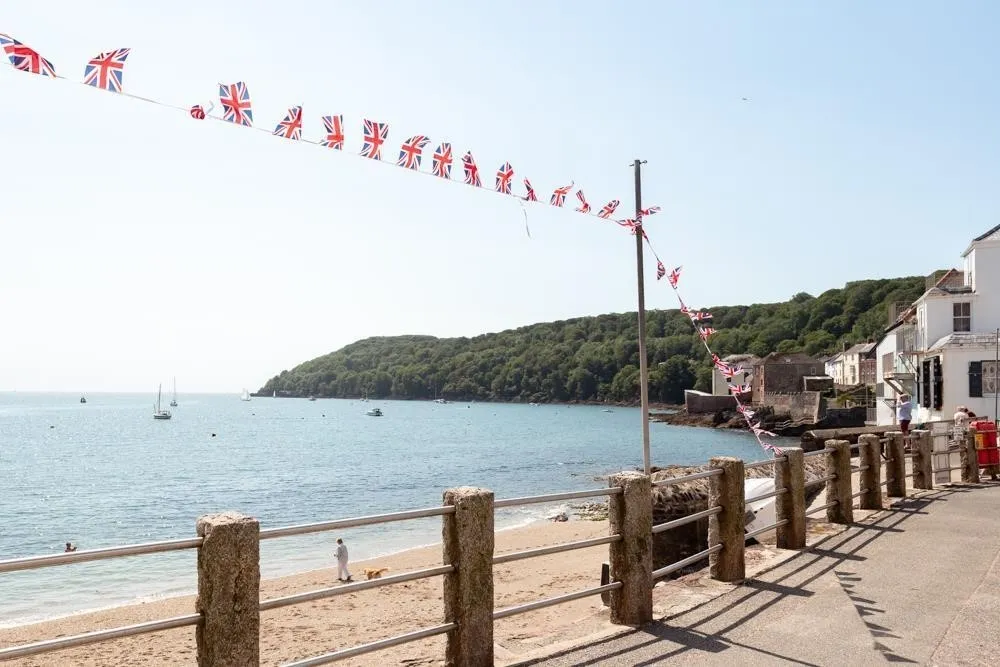 A beach with a fence and rows of flags. 