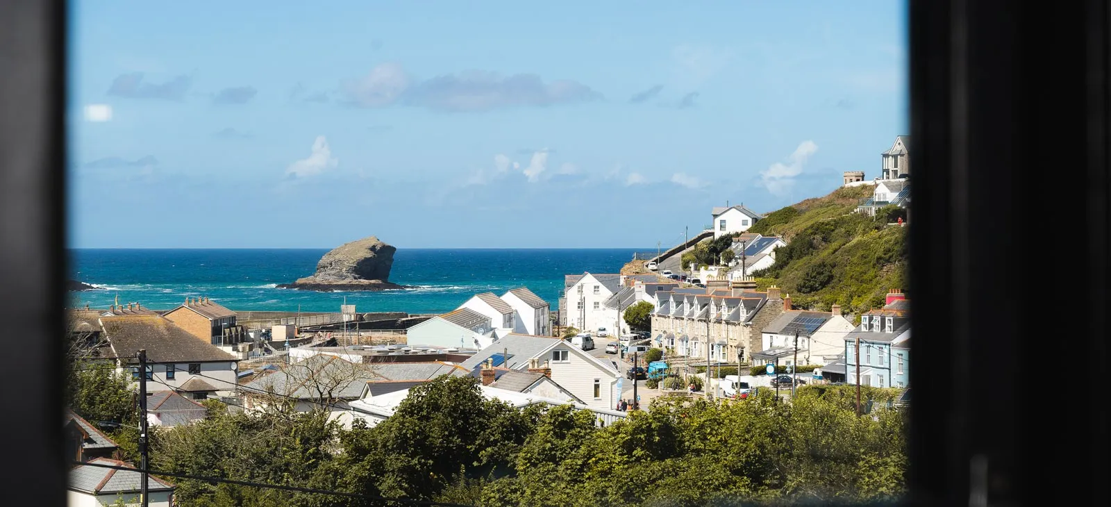 White houses on a hill by the ocean.