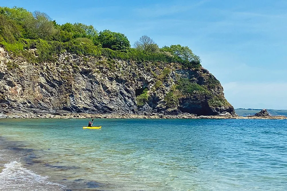 A person in a yellow kayak in the water. 