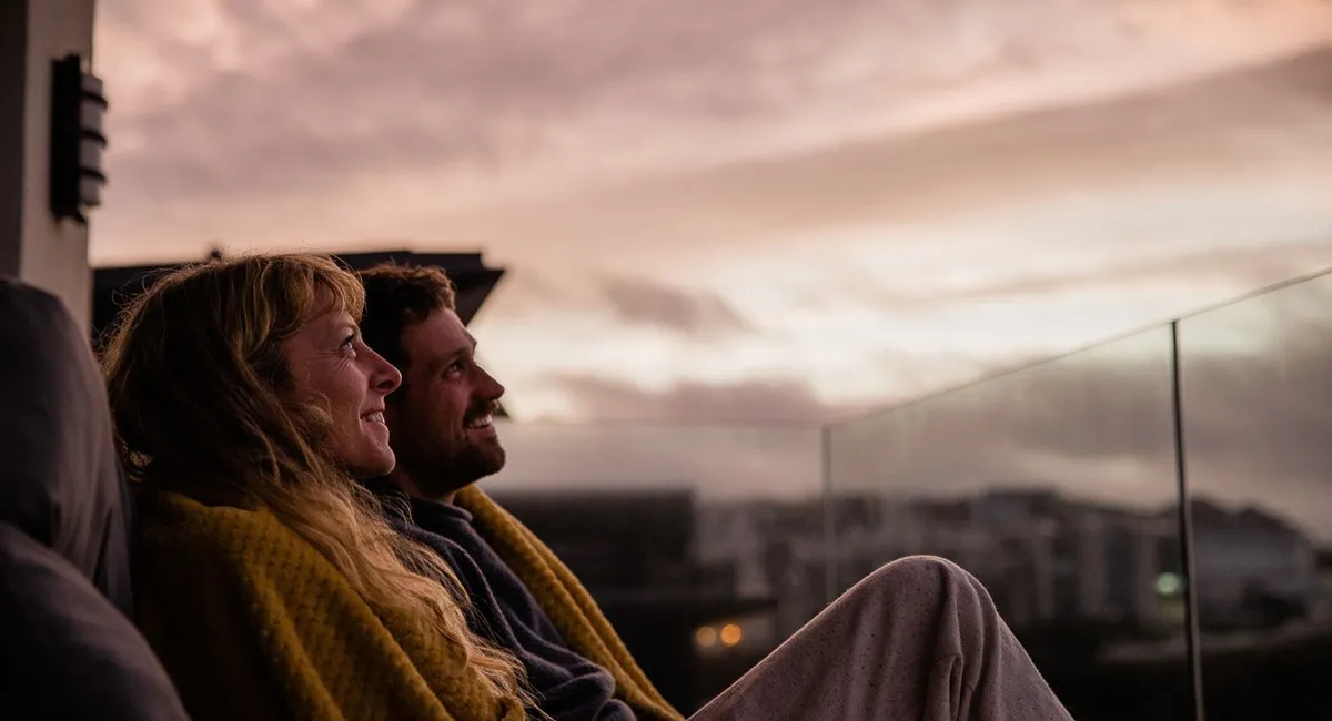 A couple sitting on a balcony.