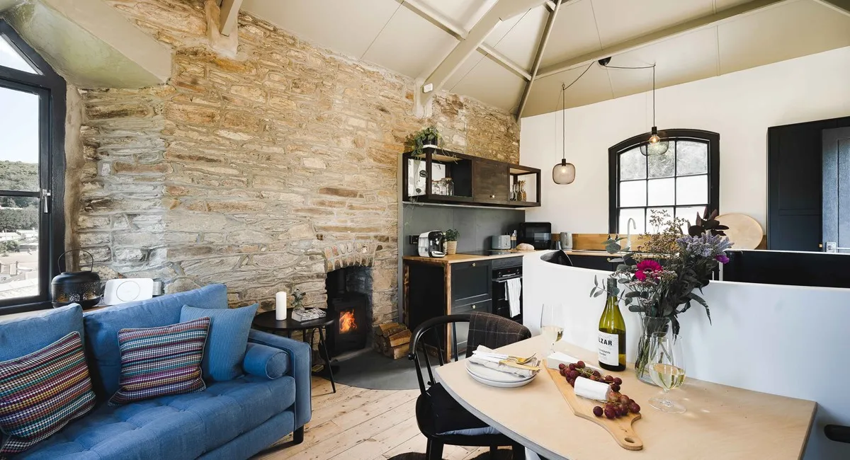 A kitchen with a fireplace and a table.