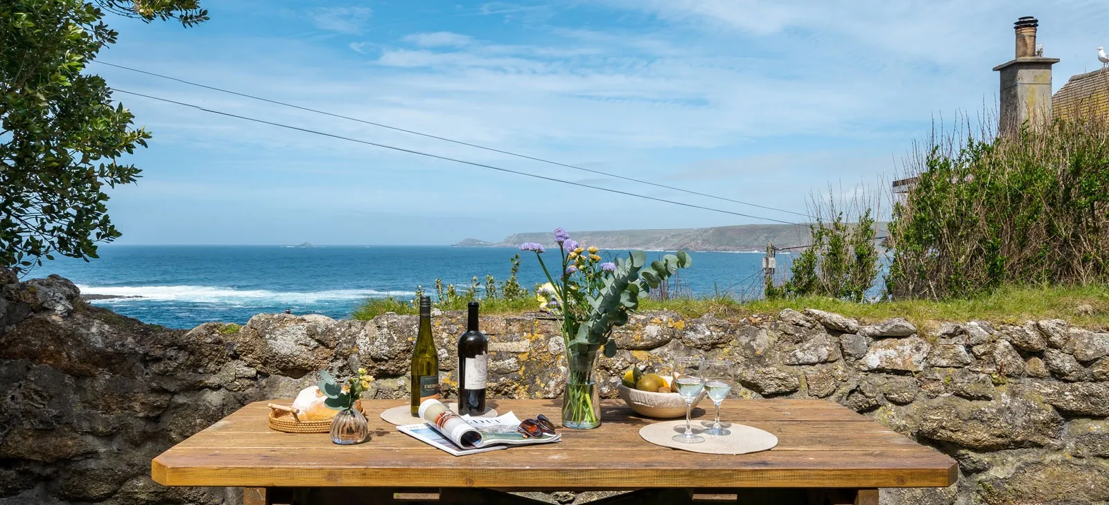 A table with wine glasses and flowers on it.