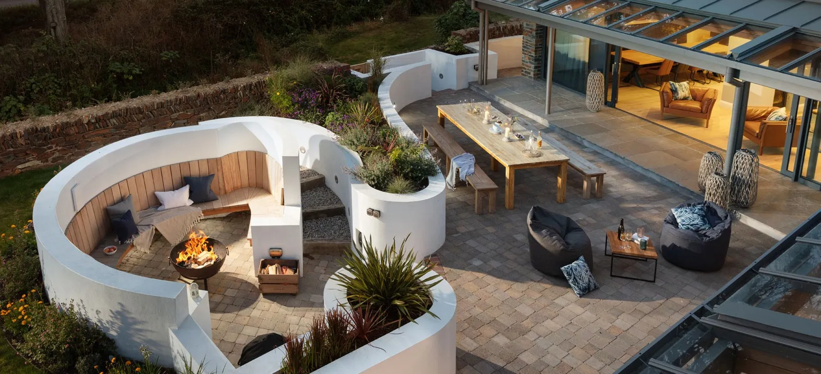 A patio area with a firepit, table and chairs.