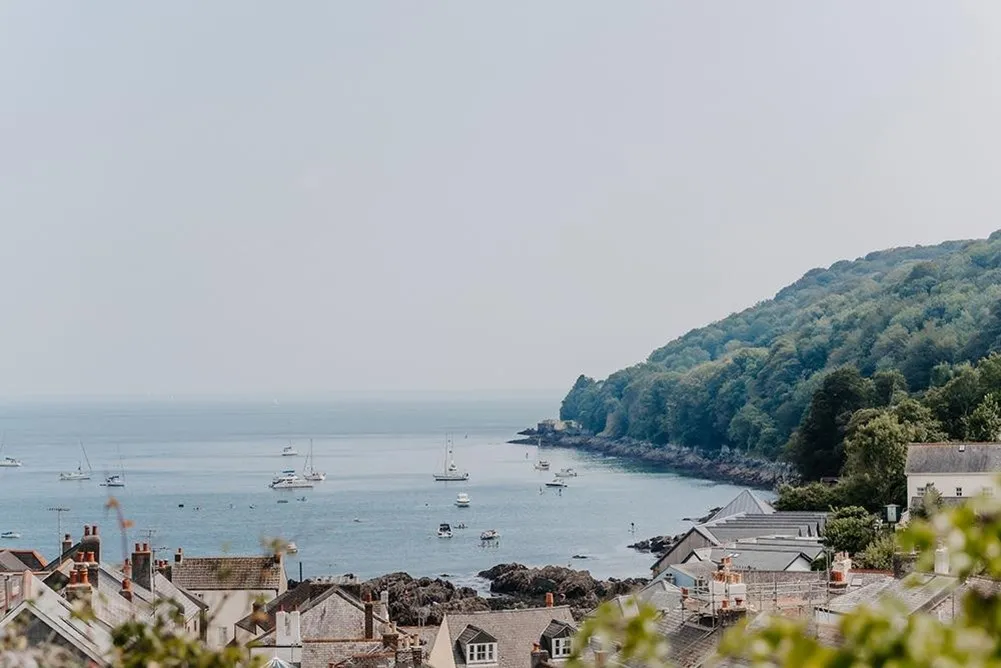 Stone houses overlooking the sea with boats on it.