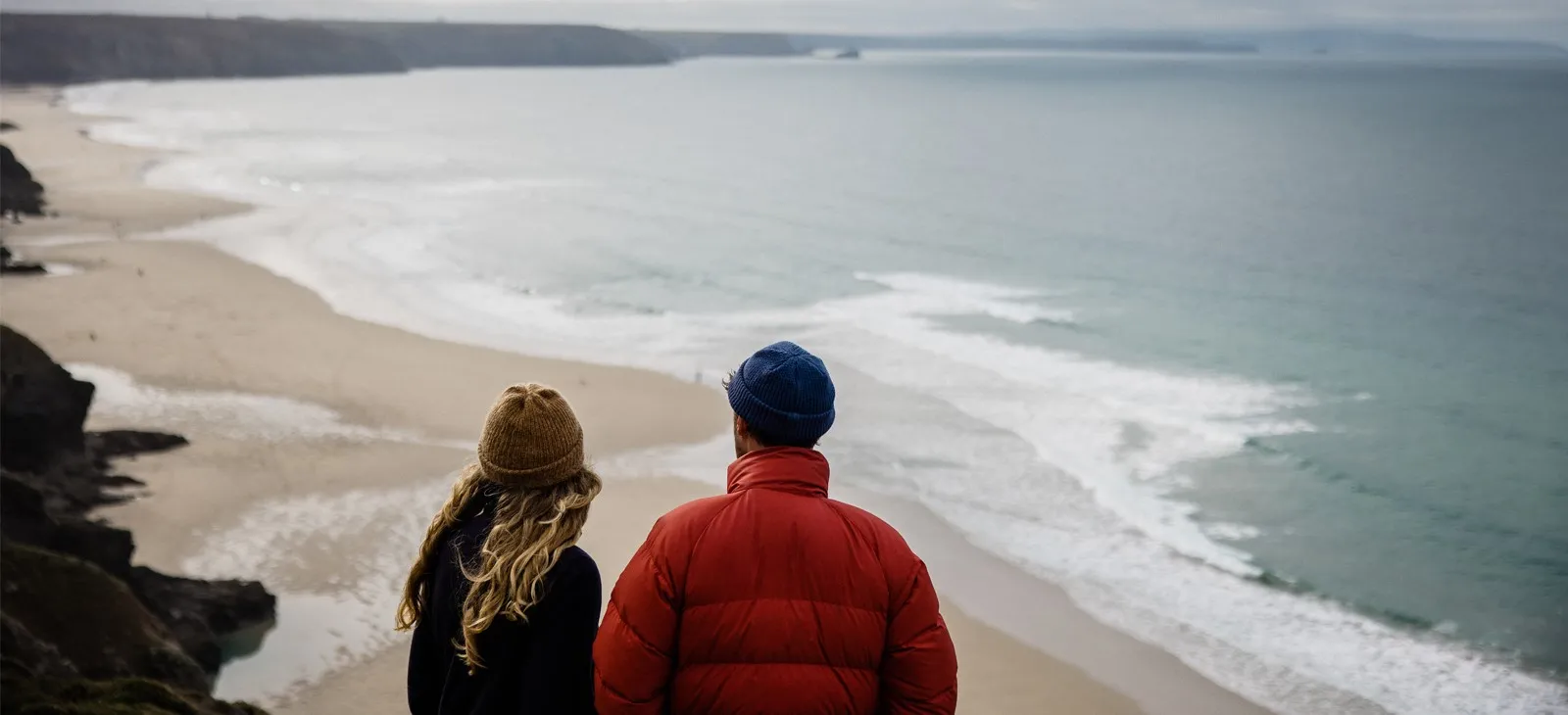 A couple looking down at the ocean.