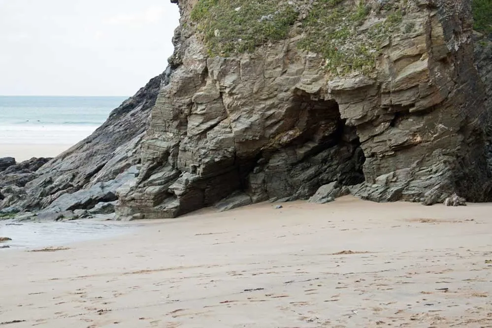 A rock cliff with a hole in it. 