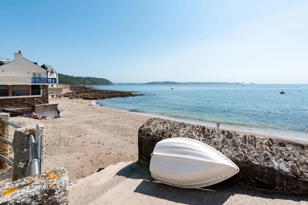 Boat resting against a beach wall.