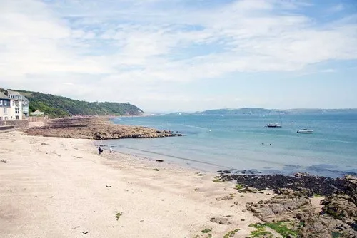 A beach with rocks and blue water. 