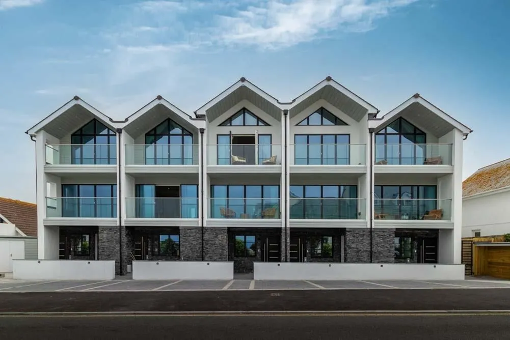 A row of white buildings with glass windows. 