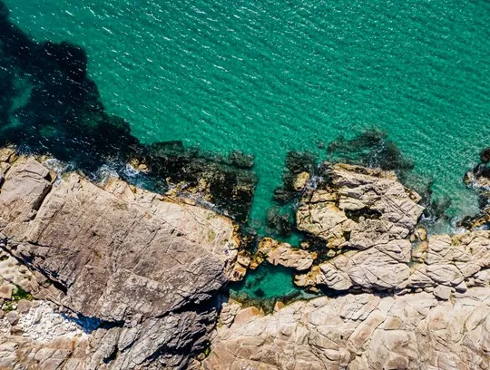 A rocky shore with blue water.