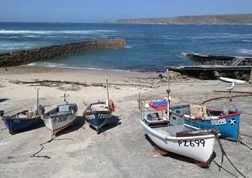 Boats on a beach with a small dock.