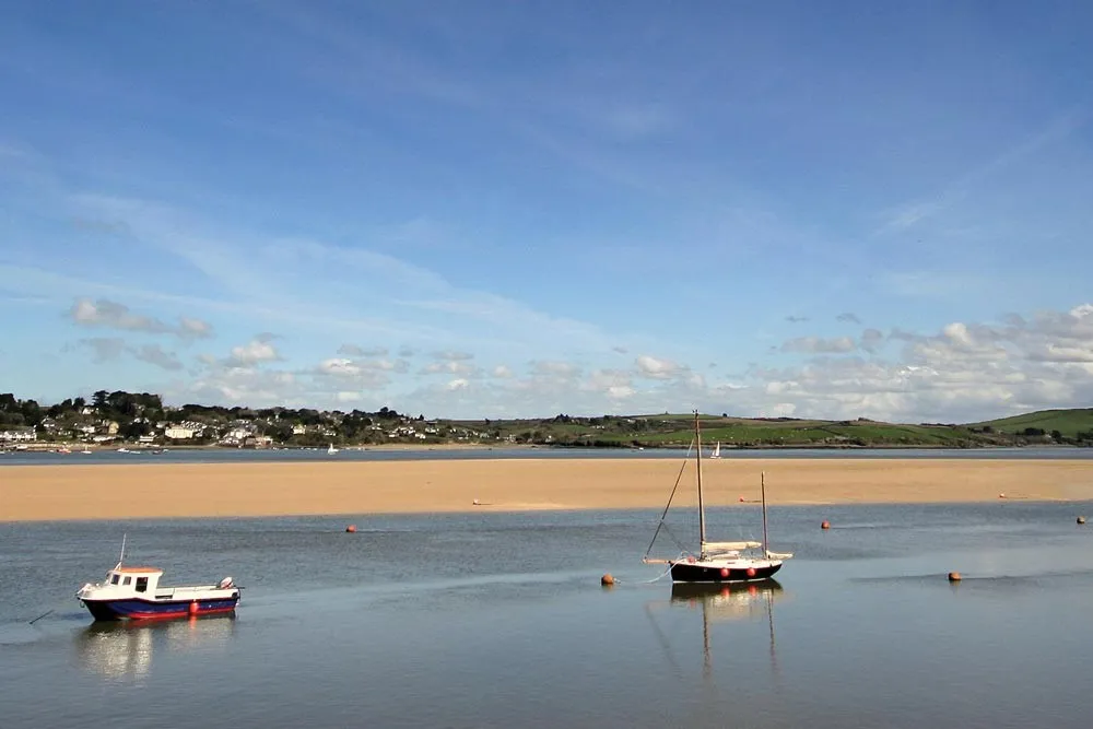 Boats anchored in the estuary at low tide.