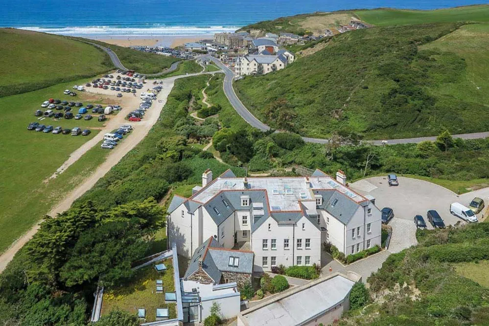 A group of buildings on a hill overlooking the sea. 