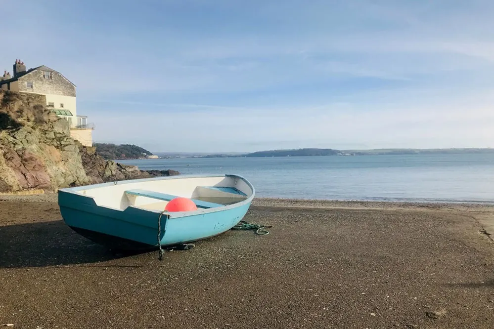 A blue boat on beach.