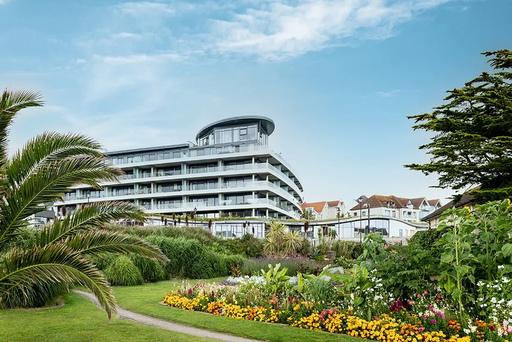 A garden with flowers and a building in the background. 