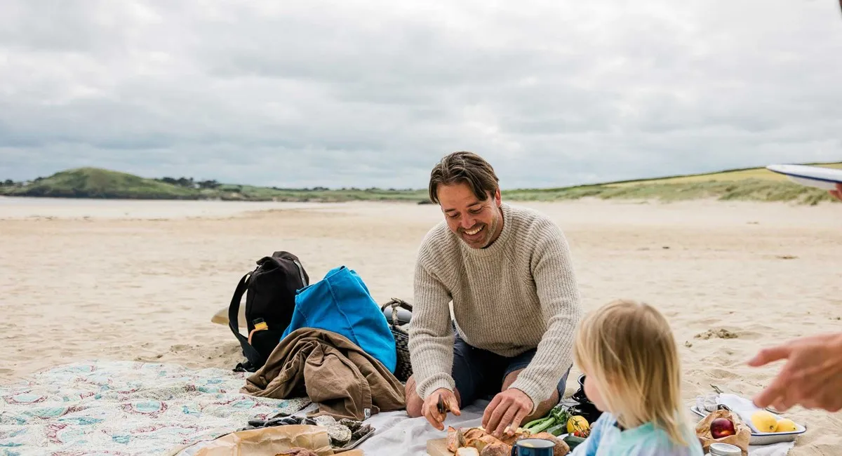 A man and child on a beach.