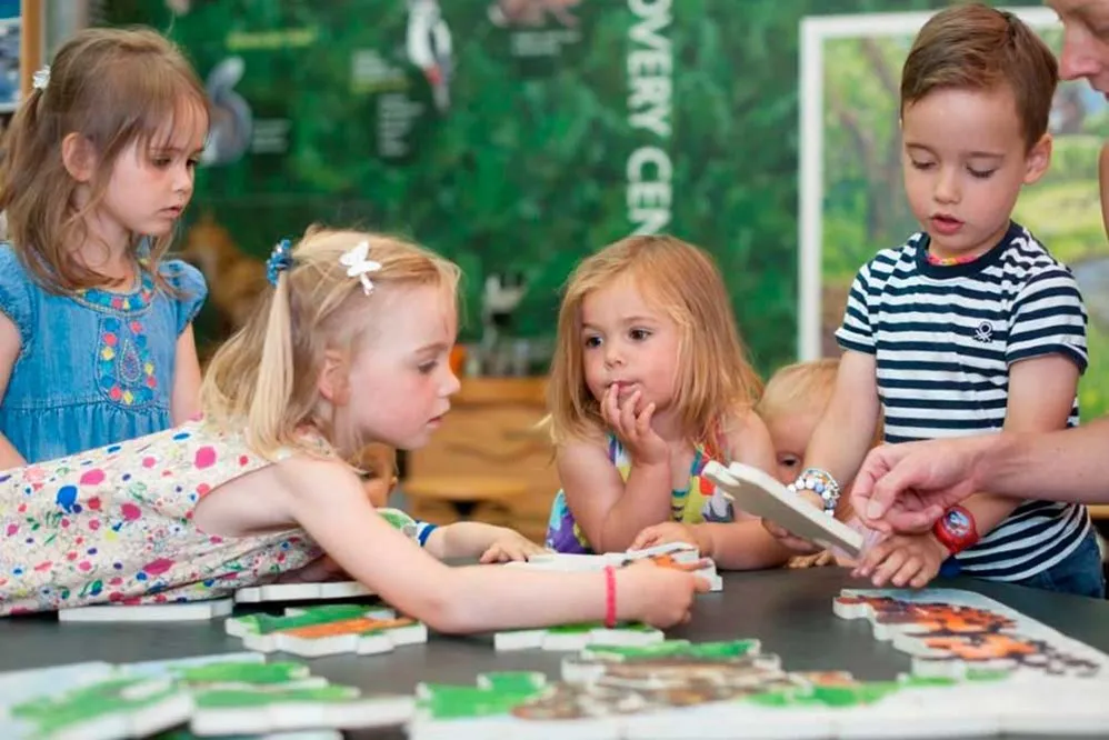 A group of children playing with puzzle pieces.