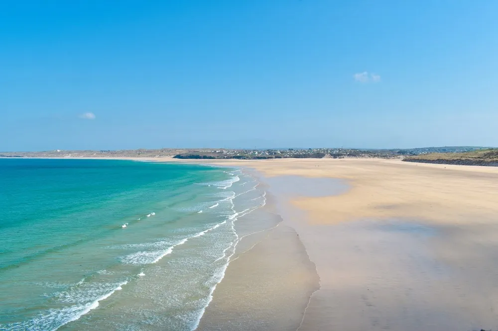 A beach with blue water and sand. 