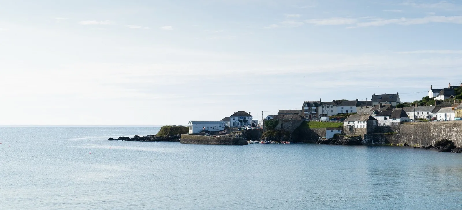 Houses on a rocky hill overlooking a small harbour.