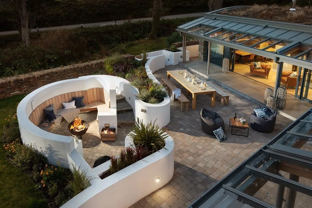 A patio area with a firepit, table and chairs.