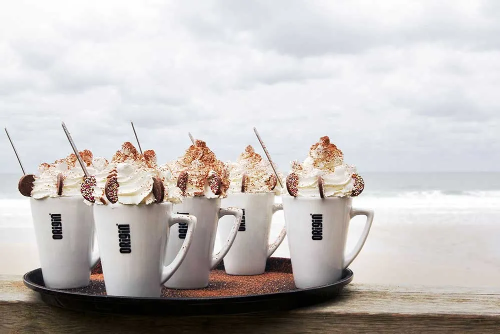 White mugs with whipped cream on top.