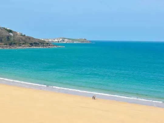 A couple of people on a white sand beach.