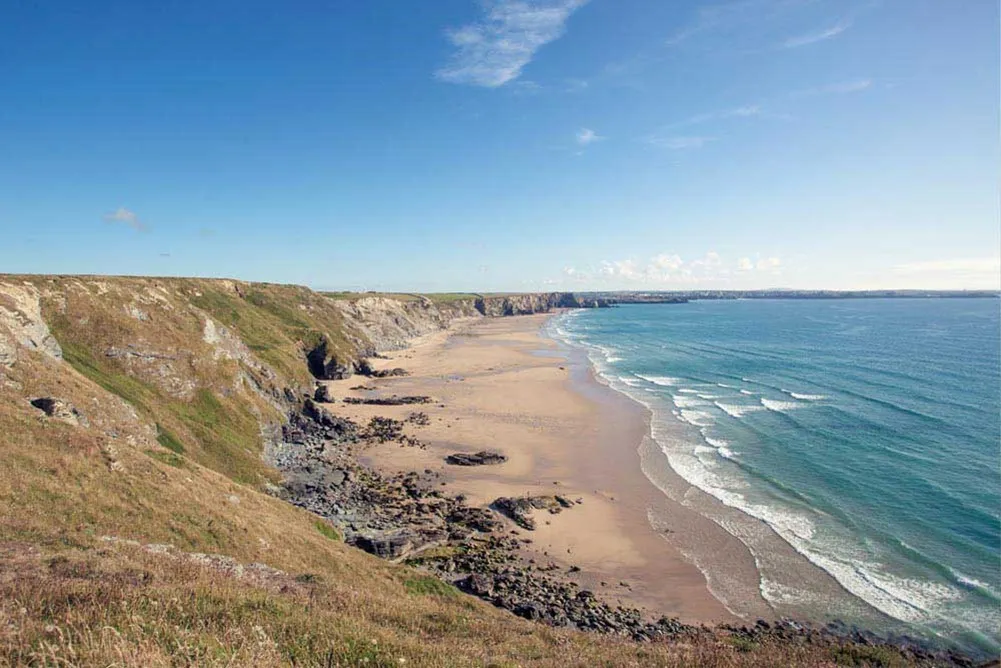 A beach with waves crashing on the shore. 