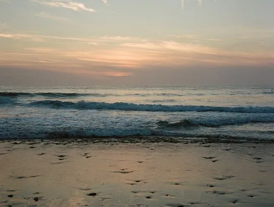 A beach with waves crashing on the shore.