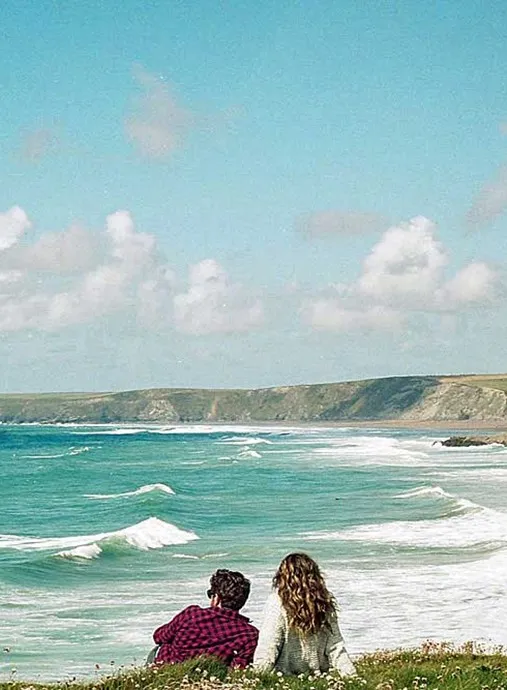 A couple of people watching the sea.