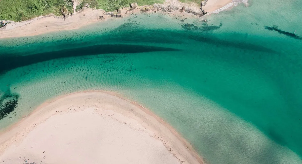 The mouth of an estuary with beaches either side.