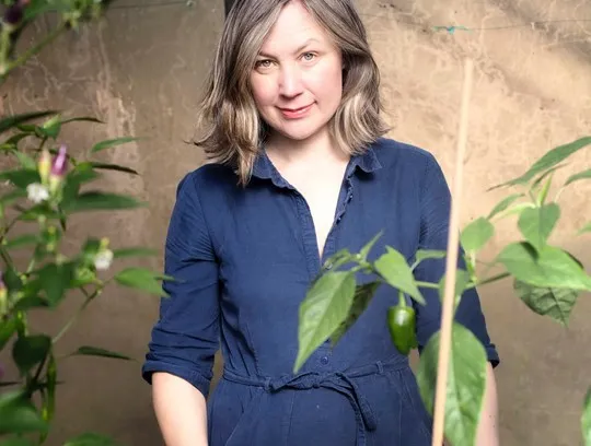 A person standing in front of a plant.