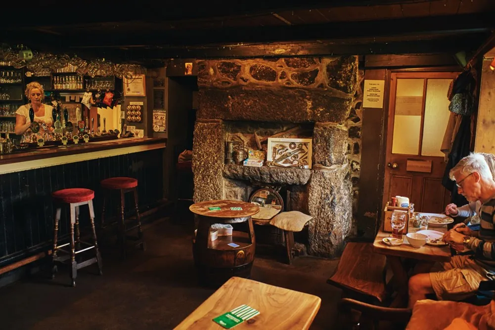 A room with a stone fireplace and tables.