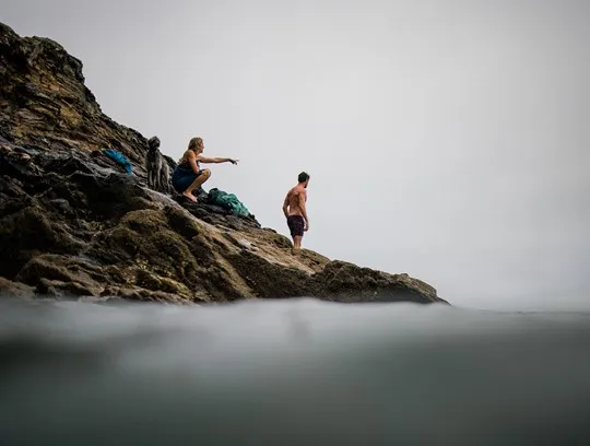 People sat on a rocky cliff.